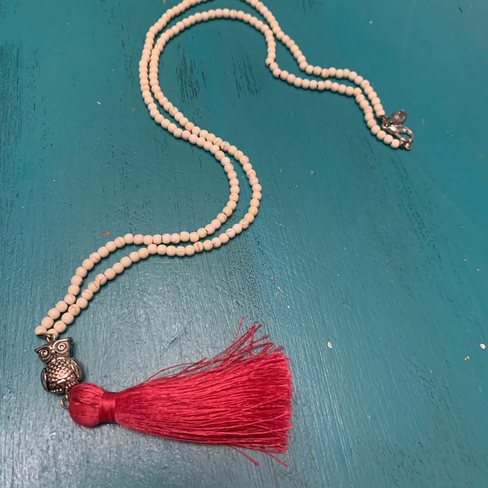 White beaded necklace with hot pink tassel